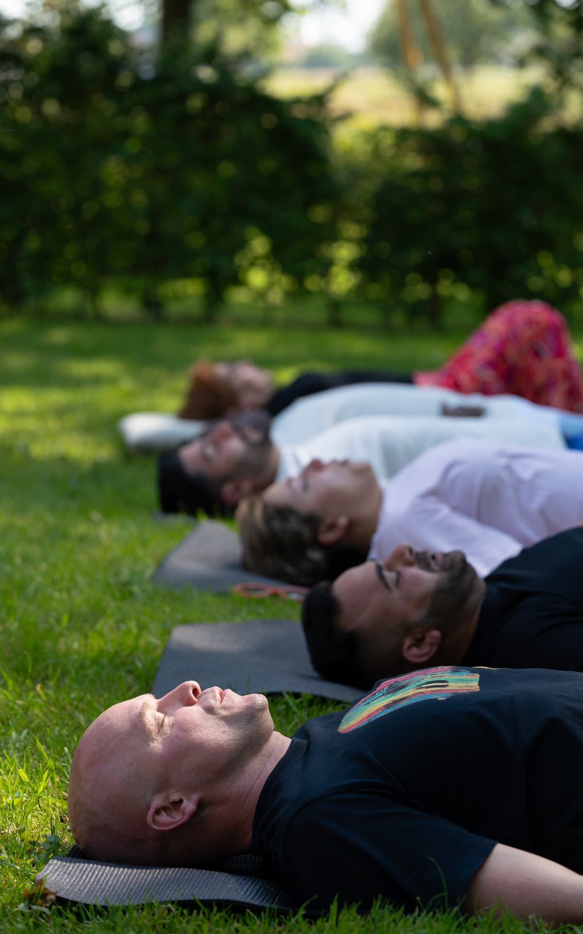 Groep tijdens een ademwerksessie buiten in het gras